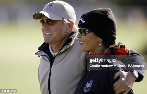 Actor Michael Douglas and wife Catherine Zeta Jones keep warm during a practice round on the Old Course, at St Andrews, Fife, Tuesday September 27,...