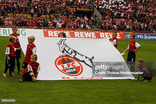 Children holding a flag of Koeln on the pitch prior the Bundesliga match between 1. FC Koeln and Bayern Muenchen at the RheinEnergie stadium on...