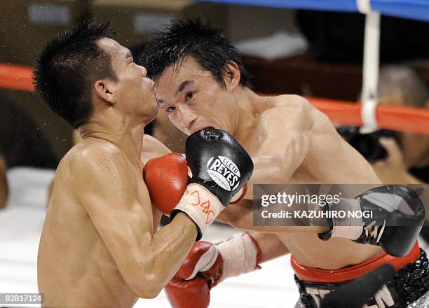 Japan's Toshiaki Nishioka connects with a left against Napapol Kiatisakchokchai of Thailand during their WBC super-bantamweight title bout in...