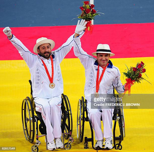 Michael Jeremiasz and Stephane Houdet of France gesture after receiving their gold medals following victory over Sweden's Stefan Olsson and Peter...