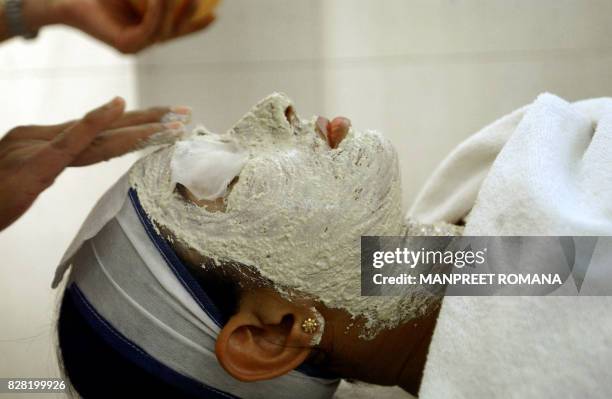 In this picture taken 19 October 2005, An Indian woman receives a facial at a beauty salon in New Delhi. In India's newspapers matrimonial...