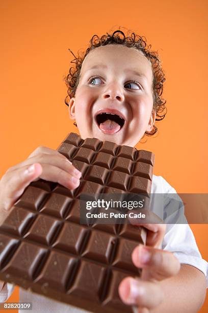 boy about to eat large bar of chocolate - chocolate eating stock pictures, royalty-free photos & images