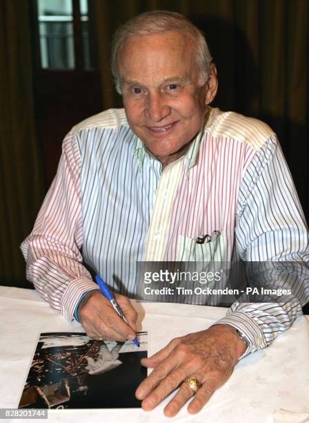 Astronaut Buzz Aldrin signing a photo at the International Autograph Auction show held near Heathrow, Saturday October 29, 2005. Other items on sale...