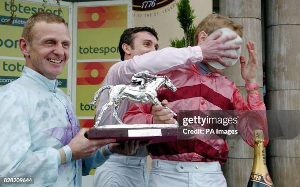 S Champion jockey Jamie Spencer has a cake pushed in his face by jockey Tony Culhane after Kevin Darley presented his trophy at Doncaster racecourse,...