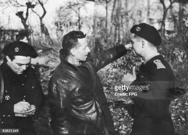 Member of the Maquis, rural guerrillas of the French Resistance, is questioned by the French Vichy government militia, the Milice, in Haute-Savoie,...