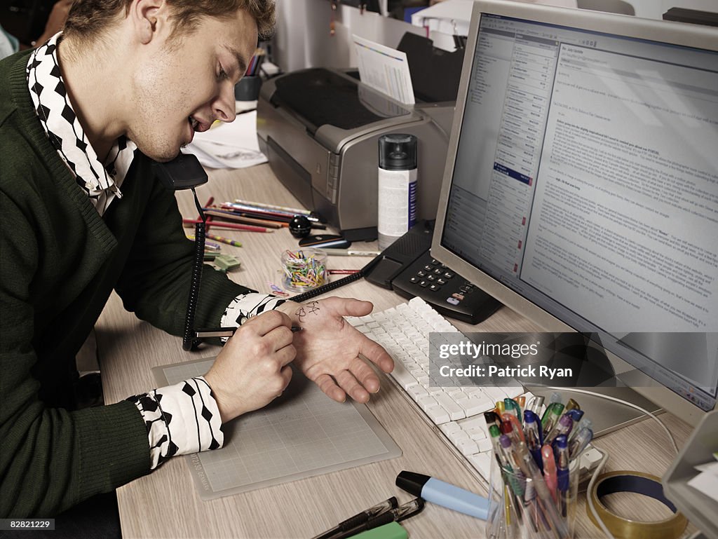 Man writing down notes on his hand