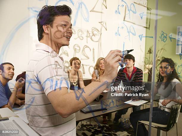 office leader explaining writing on the glass wall - genomskinlig skrivtavla bildbanksfoton och bilder