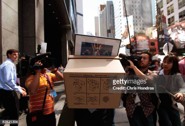 An employee of Lehman Brothers Holdings Inc. Carries a box out of the company's headquarters as he is followed by the media September 15, 2008 in New...