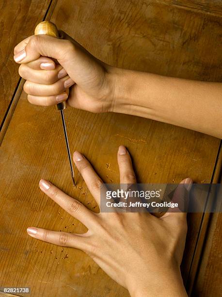 woman playing dangerous game with ice pick - icepick stock pictures, royalty-free photos & images