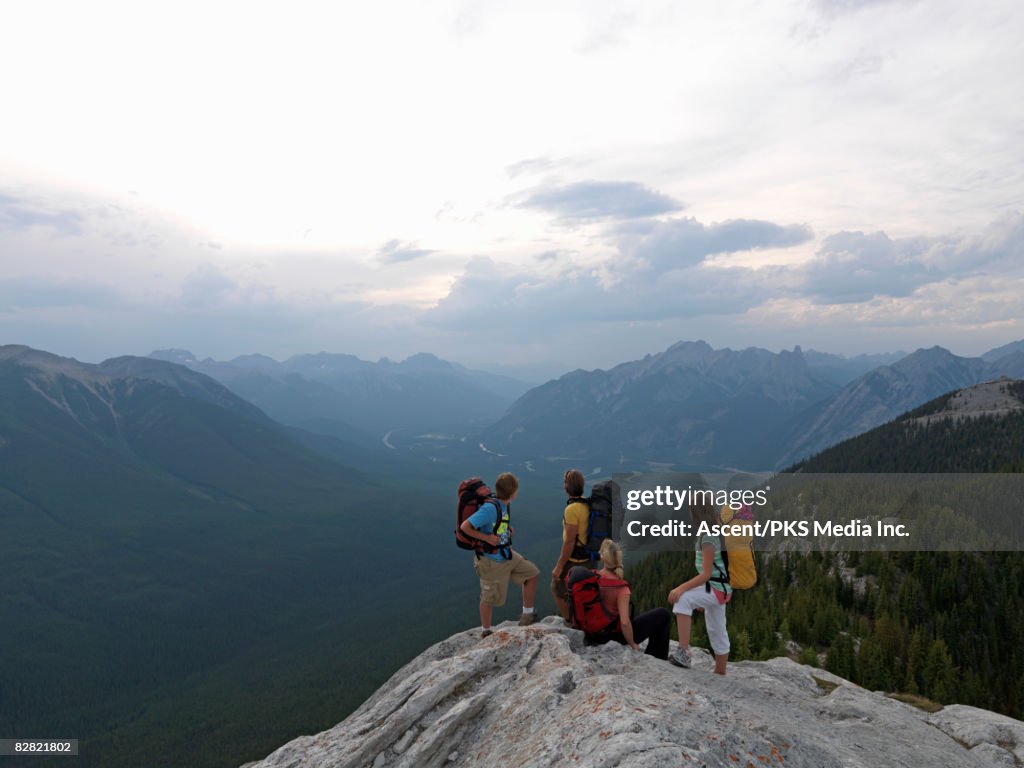 Family of hikers looking at view from mtn summit