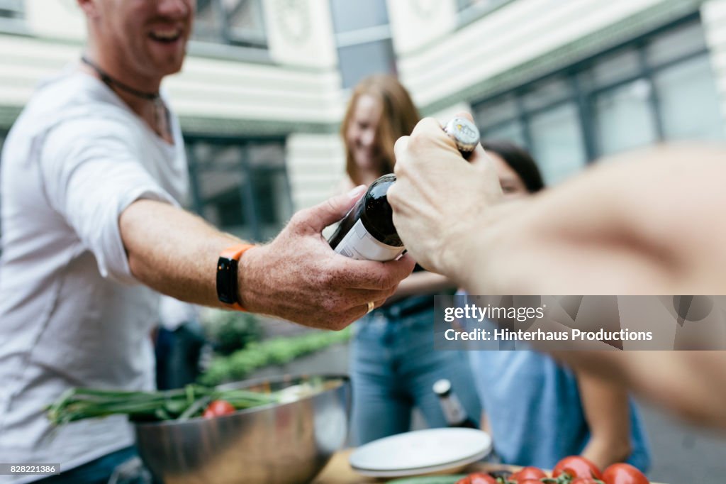 Man Handing A Beer To His Friend