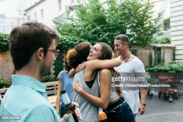 two young girls hugging at meetup with friends for a barbecue - day 4 stock-fotos und bilder