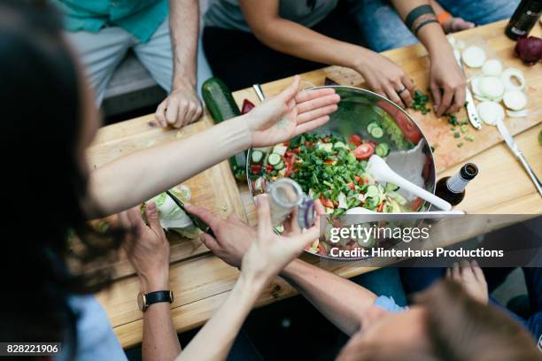 group of friends preparing food for barbecue together - kochen nahaufnahme stock-fotos und bilder