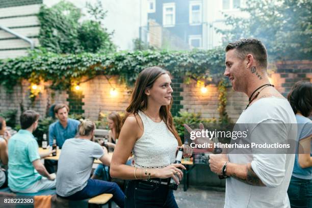 two friends chatting while attending summer barbecue - german greens party stockfoto's en -beelden