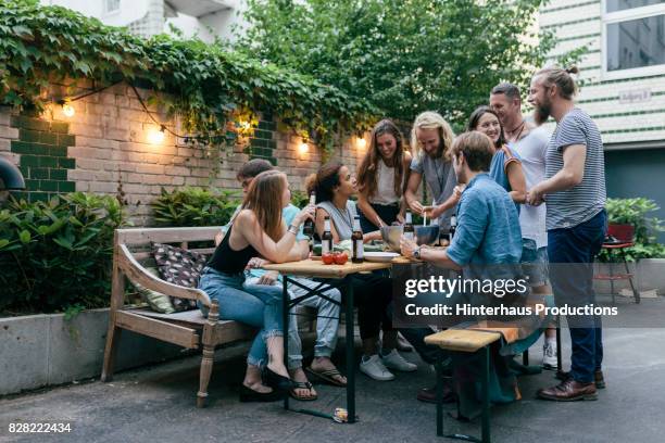 group of friends drinking and preparing food for barbecue together - discussion germany outdoor friends stock-fotos und bilder