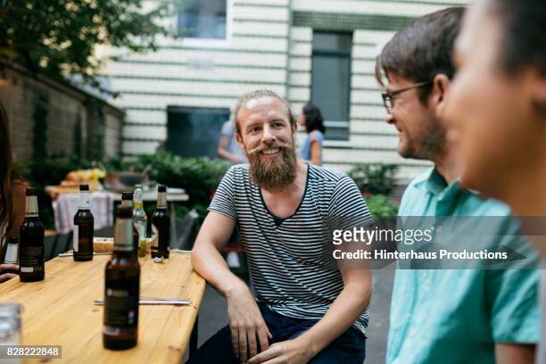 friends chatting after dinner and drinks at barbecue - discussion germany outdoor friends stock-fotos und bilder