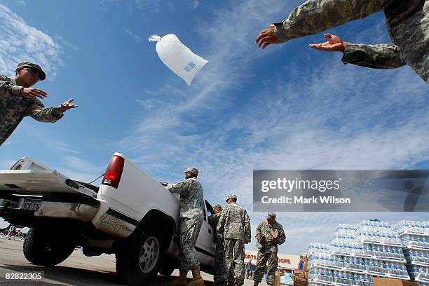 Members of the Texas National Guard distribute ice to residents affected by Hurricane Ike September 15, 2008 in Galveston, Texas. FEMA has setup...