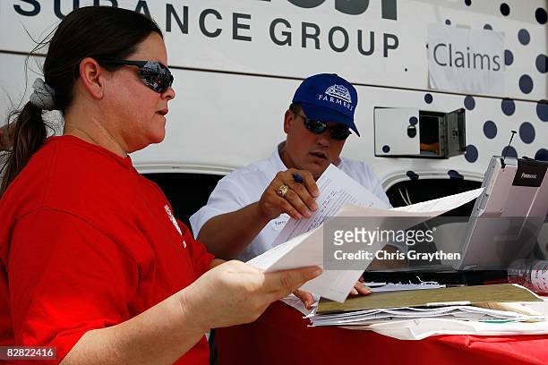 Farmer's Insurance agent Kenny Lester helps Pasadena resident Sandra Sanchez process her claim after suffering damage from Hurricane Ike September...