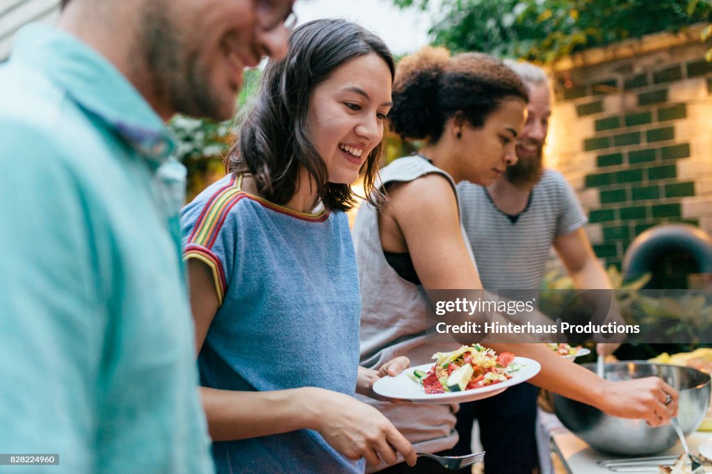 Friends Having Summer Barbecue Together Line Up For Food