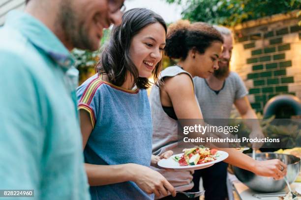 friends having summer barbecue together line up for food - 20s talking serious bildbanksfoton och bilder