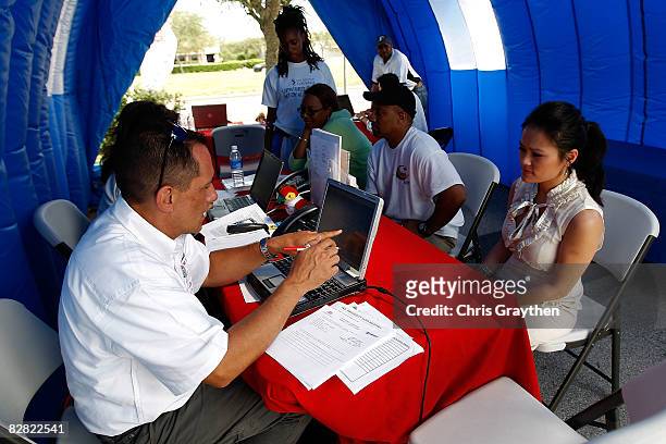 Farmer's Insurance agent Jim Baney helps Pasadena resident Tuyet Pham process her claim after suffering damage from Hurricane Ike September 15, 2008...