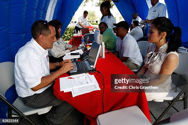 Farmer's Insurance agent Jim Baney helps Pasadena resident Tuyet Pham process her claim after suffering damage from Hurricane Ike September 15, 2008...