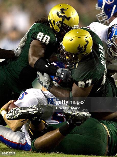 Defenders Jarriett Buie and Terrell McClain of the South Florida Bulls sack quarterback Todd Reesing of the Kansas Jayhawks during the game on...