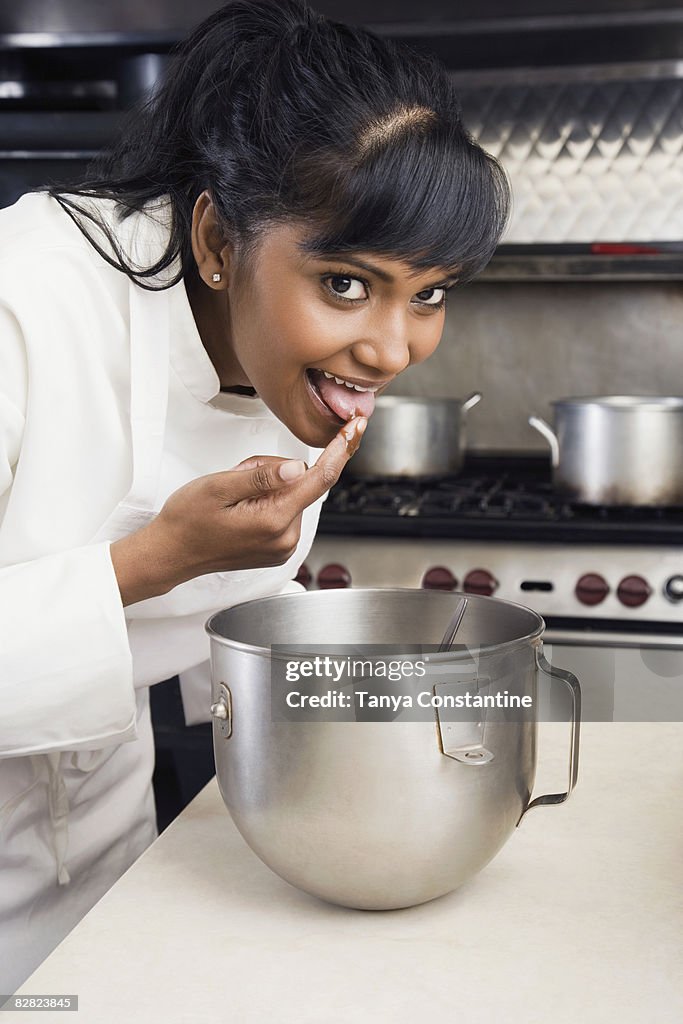 Female pastry chef tasting batter