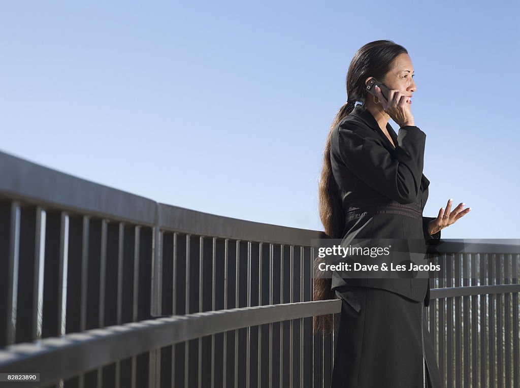 Native American businesswoman talking on cell phone outdoors