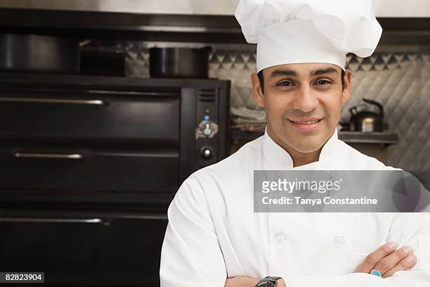 hispanic male chef with arms crossed - chefs hat stock pictures, royalty-free photos & images