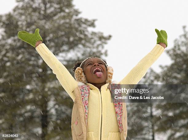 african girl catching snowflakes on her tongue - catching snow stock pictures, royalty-free photos & images