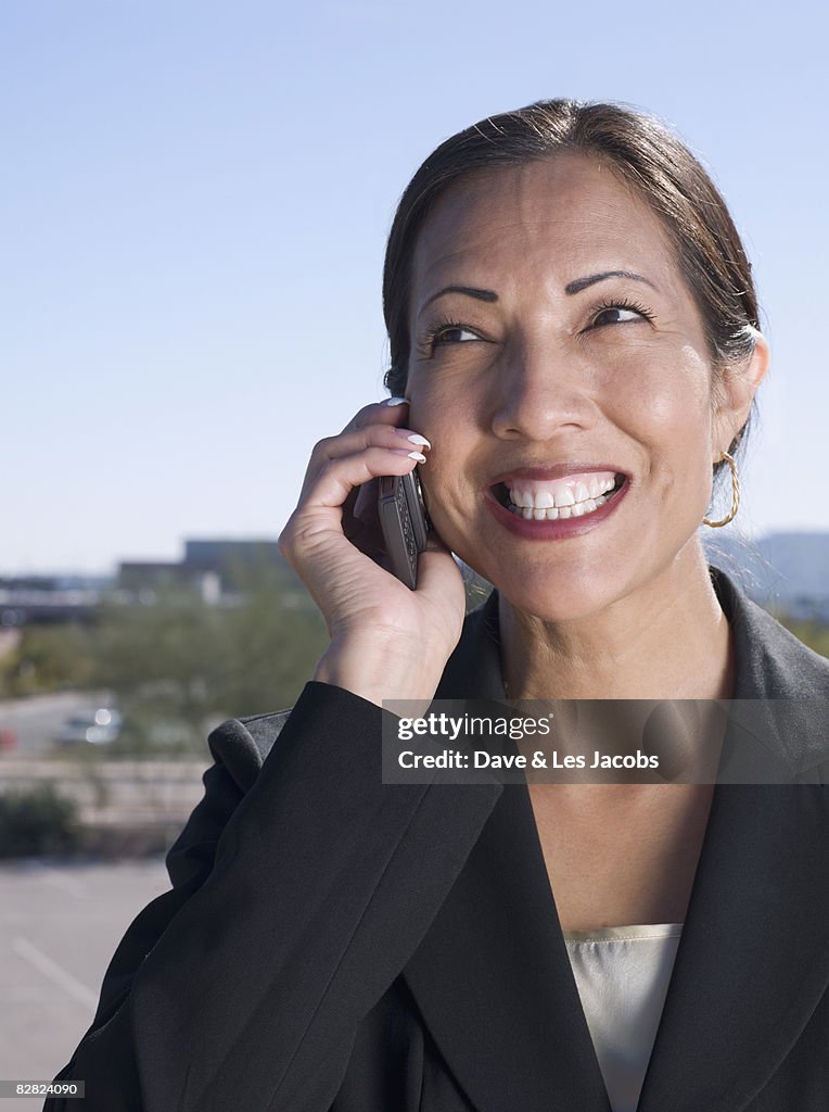 Native American businesswoman talking on cell phone outdoors