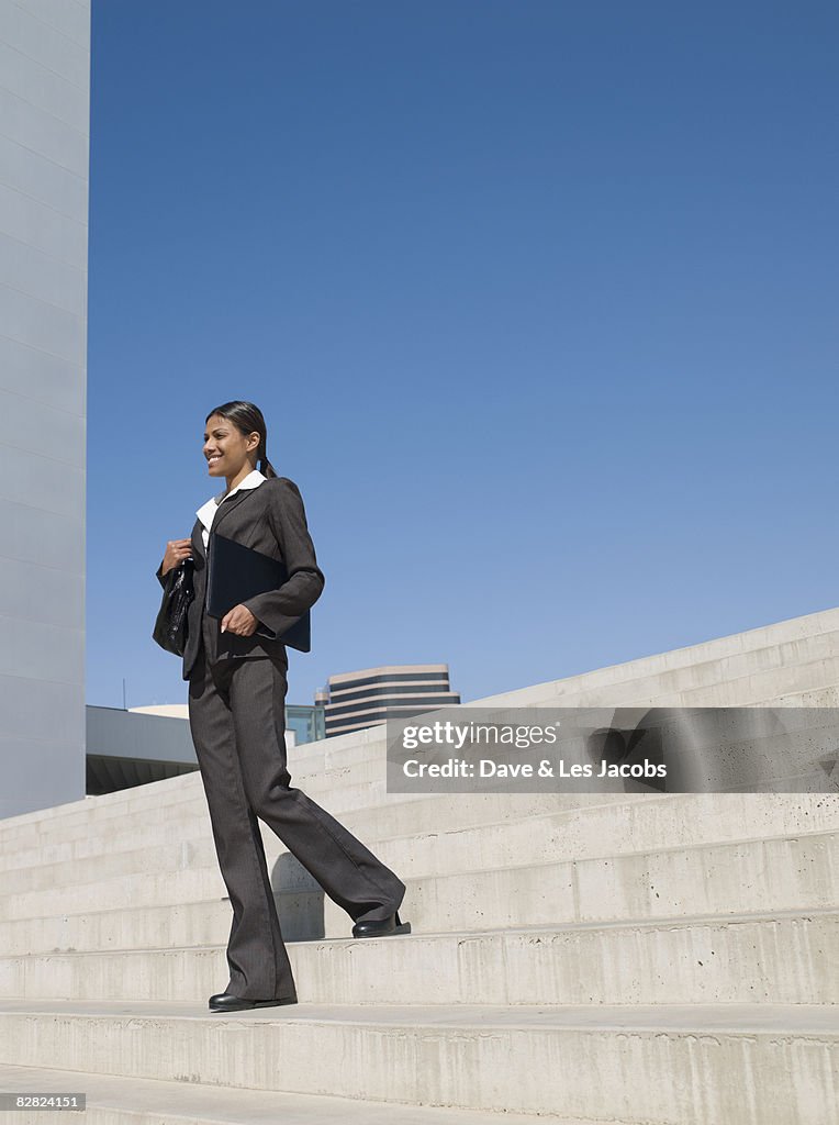 Indian businesswoman descending stairs outdoors