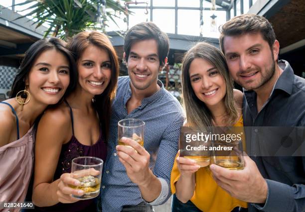 happy group of friends having drinks at the bar - whiskey stock pictures, royalty-free photos & images