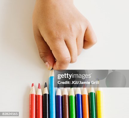 Close up of mixed race girl choosing colored pencil Close up of mixed race girl choosing colored pencil