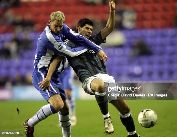 Newcastle United's Albert Luque is tackled by Wigan Athletic's Stephane Henchoz during the Carling Cup fourth round match at the JJB Stadium, Wigan,...