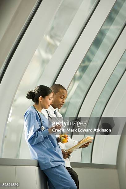 doctor and nurse reviewing medical chart - multitasking nurse stock pictures, royalty-free photos & images