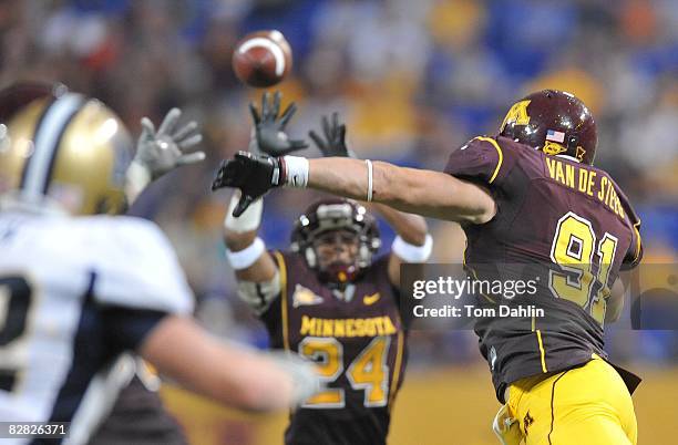 Willie VanDeSteeg of the Minnesota Golden Gophers rushes the pass lading to an interception by teammate Marcus Sherels during an NCAA game against...