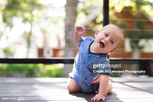 12 month old baby laughs and raises arm when excited - hot babe stock pictures, royalty-free photos & images