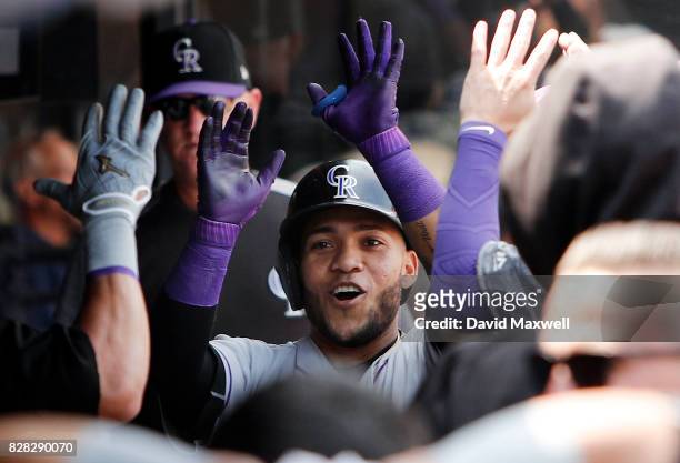 Alexi Amarista of the Colorado Rockies celebrates in the dugout after hitting a home run against the Cleveland Indians in the third inning at...