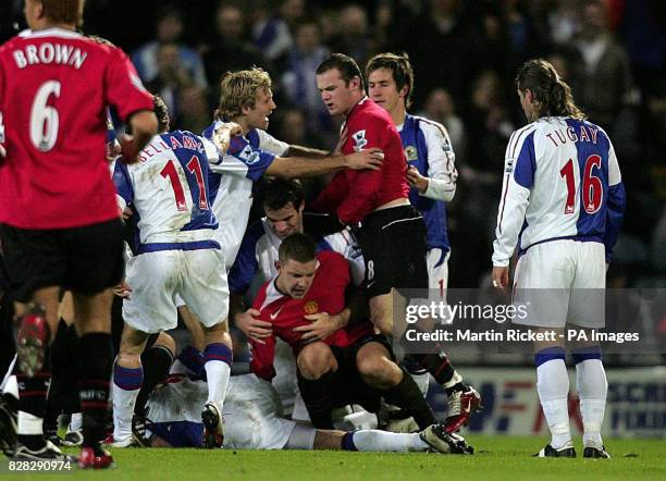 Manchester United's Alan Smith and Wayne Rooney are confronted by Blackburn Rovers players following their challenge on Robbie Savage , which led to...