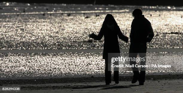 Couple walking on Dollymount strand in Dublin Saturday January 14 2006, during a break in the winter weather. However the good weather is not...