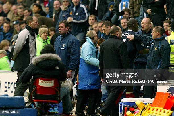 Wigan Athletic manager Paul Jewell pats West Bromwich Albion's Darren Moore on the back after he was sent of as his manager Bryan Robson argues with...