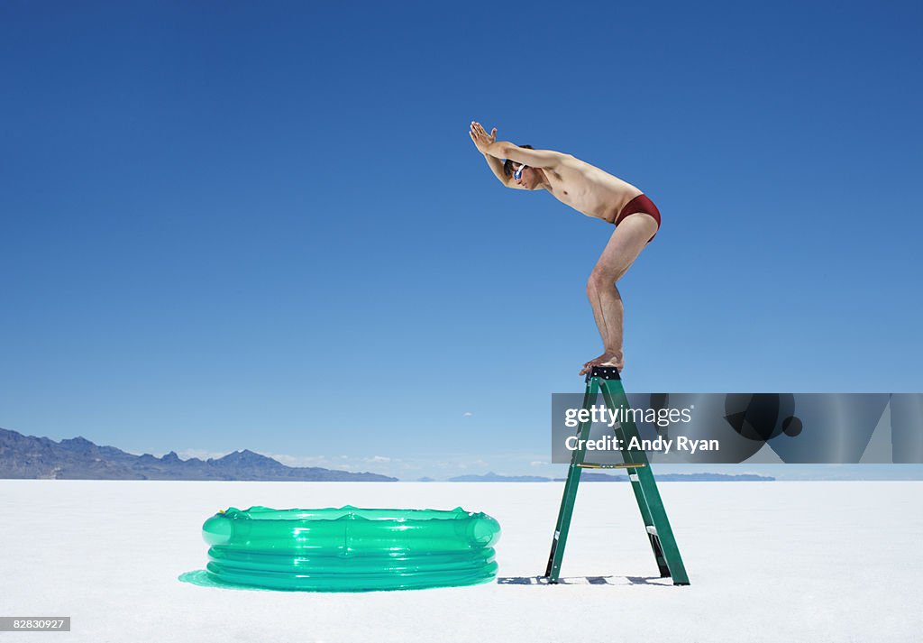 Man Diving into Inflatable Pool from Ladder.