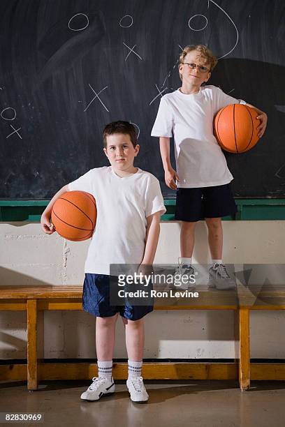 two boys holding basketballs in gym - blackboard qc stock pictures, royalty-free photos & images