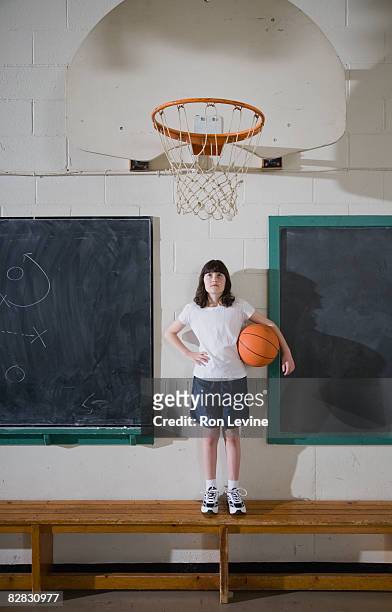 young girl holding basketball in gym - blackboard qc stock-fotos und bilder