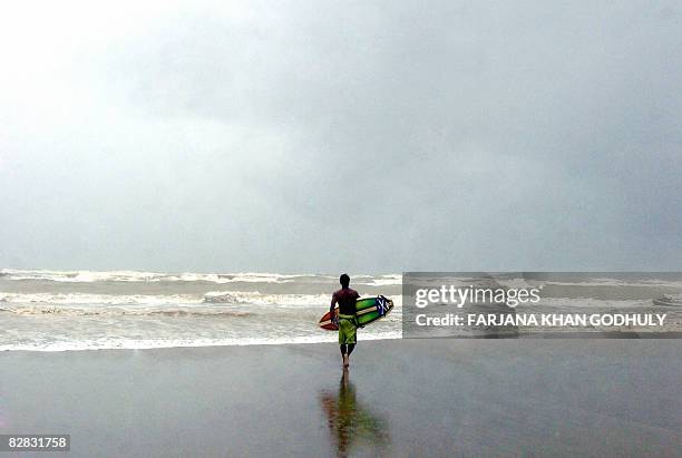 Lifestyle-Bangladesh-surfing,FEATURE" by Julie Clothier Bangladeshi surfer Jafar Alam prepares to surf in the waters of The Bay of Bengal at Cox's...