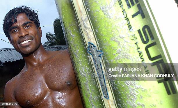 Lifestyle-Bangladesh-surfing,FEATURE" by Julie Clothier Bangladeshi surfer Jafar Alam poses with his surf board at his home in Cox's Bazar on June...