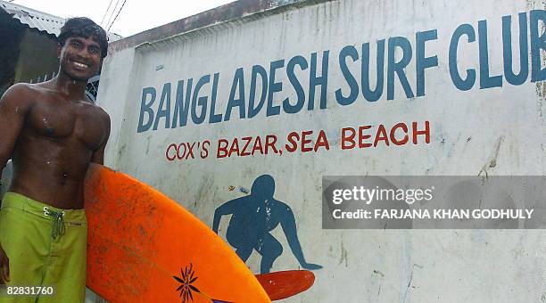 Lifestyle-Bangladesh-surfing,FEATURE" by Julie Clothier Bangladeshi surfer Jafar Alam poses with his surf board at his home in Cox's Bazar on June...