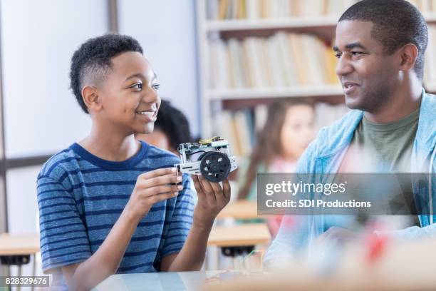 father and son discuss robot project at school - father and children volunteering imagens e fotografias de stock